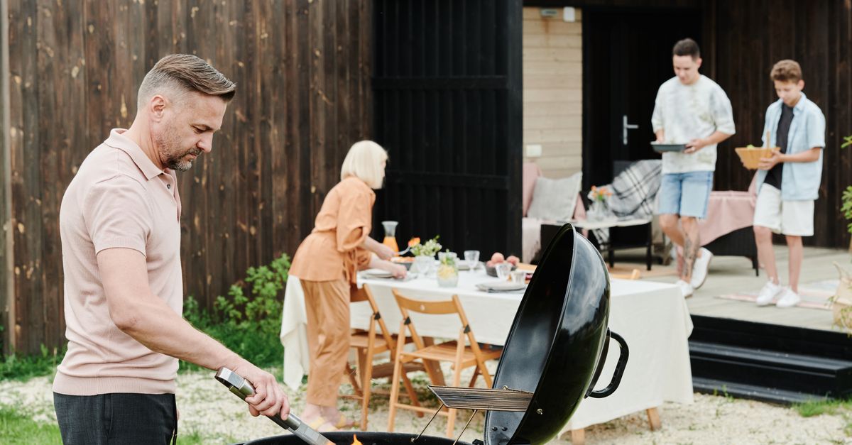 A happy family enjoys an outdoor barbecue in their backyard, fostering togetherness.